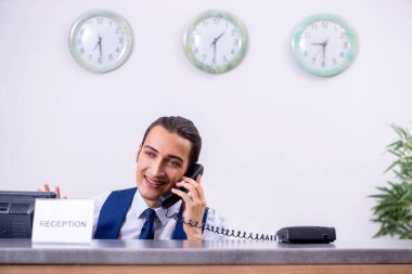 Otel resepsiyonundaki genç adam.