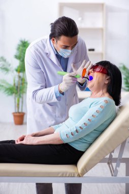 Yaşlı kadın genç dişçiyi ziyaret ediyor.