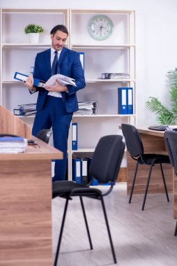 Genç yakışıklı işadamı ofiste çalışıyor.