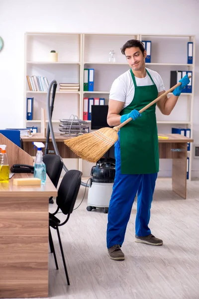 Jonge knappe aannemer schoonmaken van het kantoor — Stockfoto