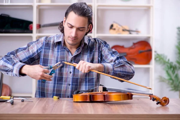 Jeune beau réparateur réparer violon — Photo