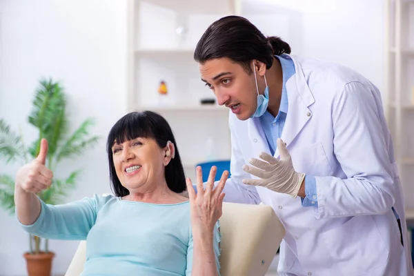 Yaşlı kadın genç doktor laringologu ziyaret ediyor. — Stok fotoğraf