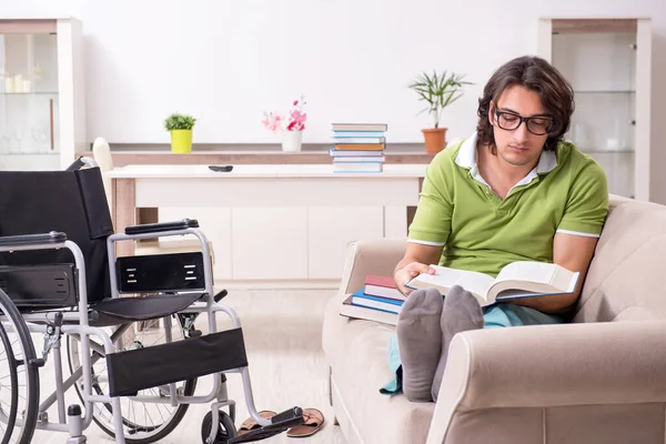 Jonge mannelijke student in rolstoel thuis — Stockfoto