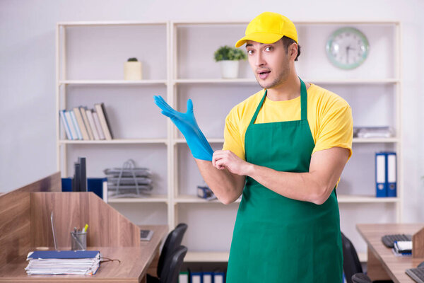 Молодой мужчина-подрядчик убирает офис