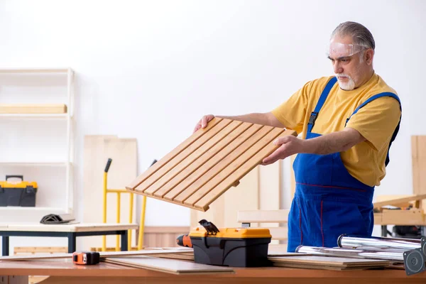 Oude mannelijke timmerman aan het werk in werkplaats — Stockfoto