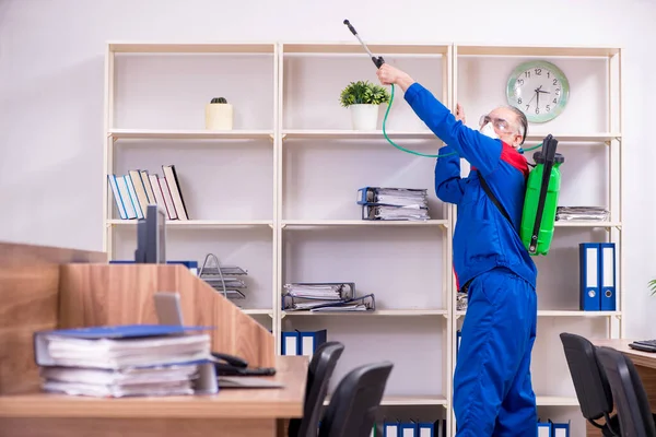 Oude professionele aannemer doet ongediertebestrijding in het kantoor — Stockfoto