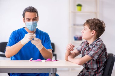 Genç çocuk hastanede doktoru ziyaret ediyor.