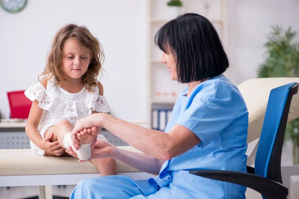 Little girl visiting old female doctor — Stock Photo, Image