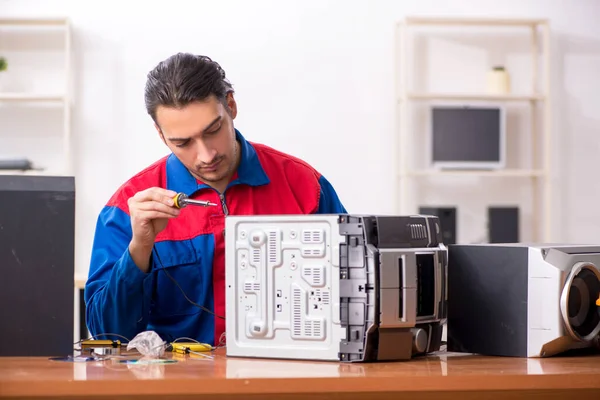 Jonge ingenieur repareert muzikaal hi-fi systeem — Stockfoto