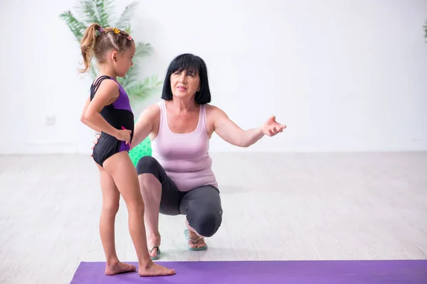 Menina e mãe se exercitando em casa — Fotografia de Stock