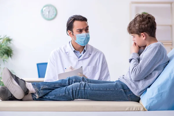 Genç çocuk hastanede doktoru ziyaret ediyor.