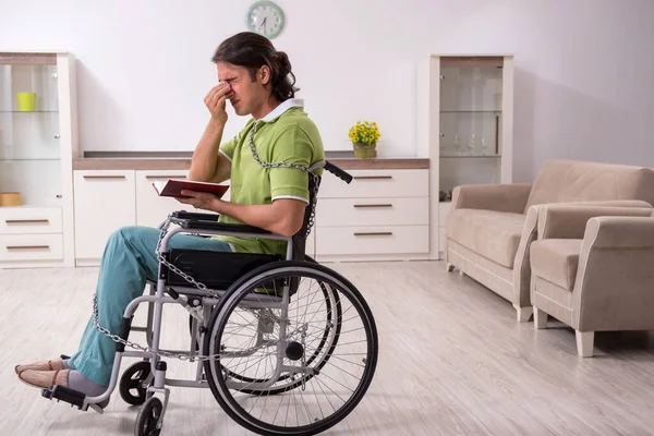 坐在轮椅上病倒的男青年在家里受苦 — 图库照片