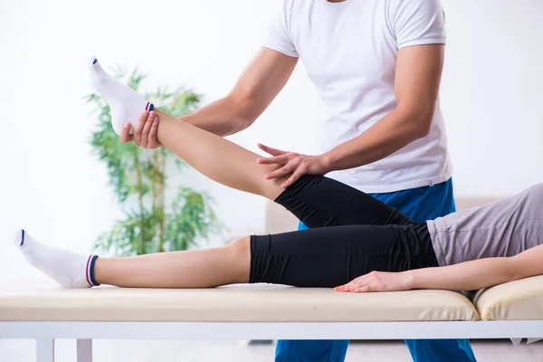 Mujer joven que visita al médico fisioterapeuta masculino — Foto de Stock