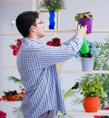 Bahçıvan çiçekçide çalışıyor. Çiçekçide çalışıyor.