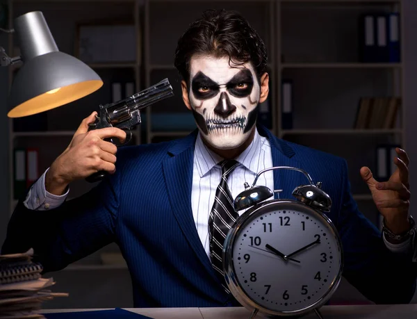 Businessman with scary face mask working late in office — Stock Photo, Image