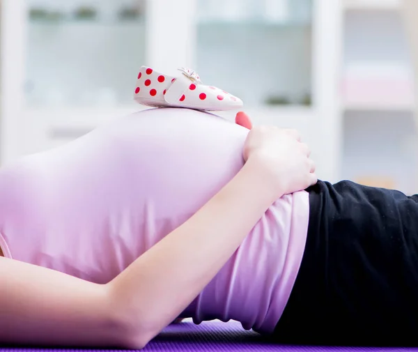 Hamile kadın çocuk doğurma beklentisiyle egzersiz yapıyor. — Stok fotoğraf