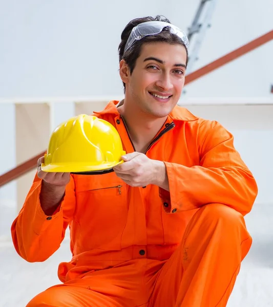 O carpinteiro usando chapéu amarelo na oficina do empreiteiro — Fotografia de Stock