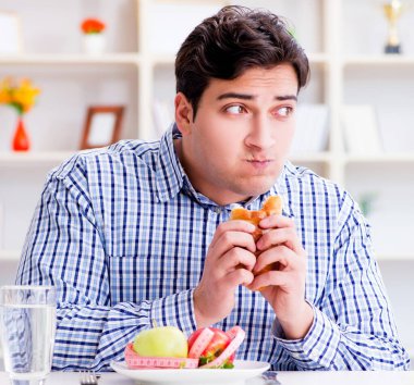 Diyet dolandırıcılığında sağlıklı yemek ve ekmek arasında ikilem yaşayan bir adam.