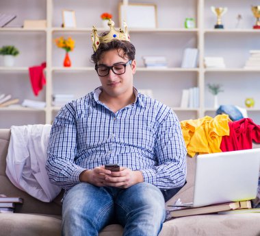 Genç adam dağınık bir odada çalışıyor.