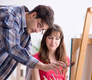 Stüdyoda resim sınıfında sanatçı koçluğu yapan bir öğrenci.