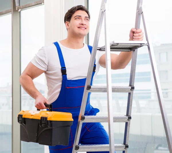Ung reparatör klätterstege på byggarbetsplats — Stockfoto