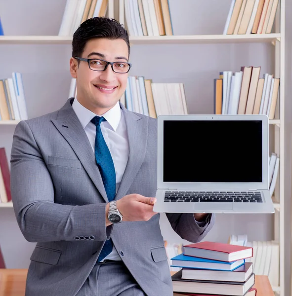 Бизнесмен с пустым экраном ноутбуком, работающий в библиотеке — стоковое фото