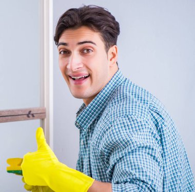 Otelde ayna temizleyen genç adam.