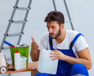 Tamirci, duvar kağıdıyla evde tadilat yapıyor.