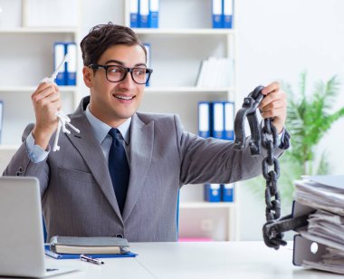 Ofis masasına zincirlenmiş meşgul bir çalışan.