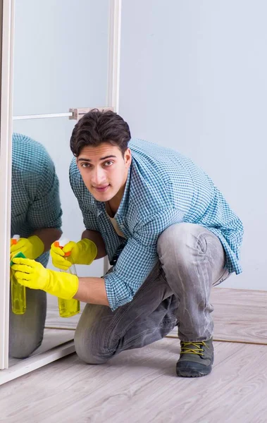 Young man cleaning mirror at home hotel — Stock Photo, Image