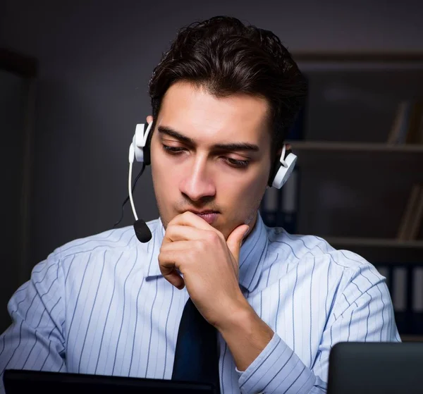 Operador de call center conversando com o cliente durante o turno da noite — Fotografia de Stock