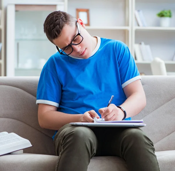 Jovem estudante se preparando para exames estudando em casa em um sofá — Fotografia de Stock