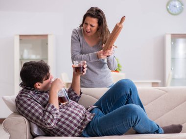 Genç bir aile kavramında içki sorunu yaşayan sarhoş bir koca.