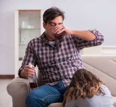 Genç bir aile kavramında içki sorunu yaşayan sarhoş bir koca.