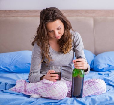 Evde alkol alan genç bir kadın depresyonda.