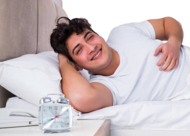 Yatakta uykusuzluk çeken bir adam.