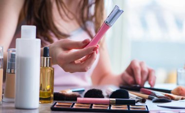 Güzellik konseptinde makyaj malzemeleri olan bir kadın.