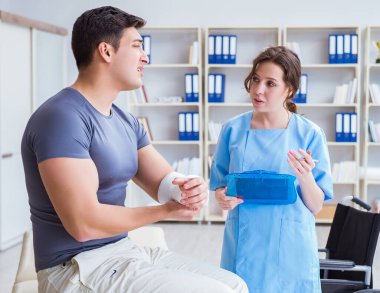 Hastanede yaralanma kontrolü sırasında doktor ve hasta.