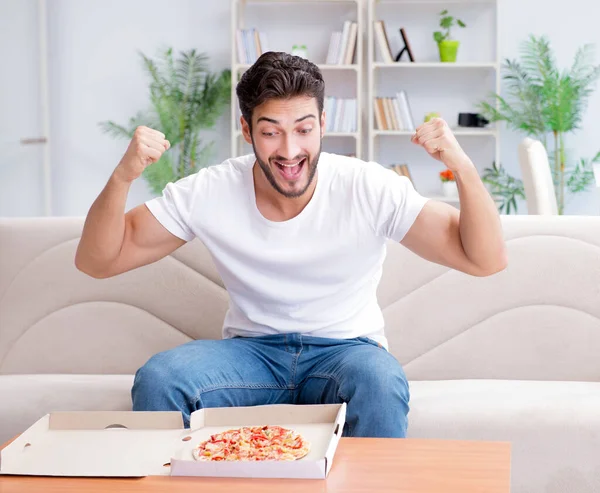 Hombre comiendo pizza teniendo una comida para llevar en casa descansando relajado — Foto de Stock