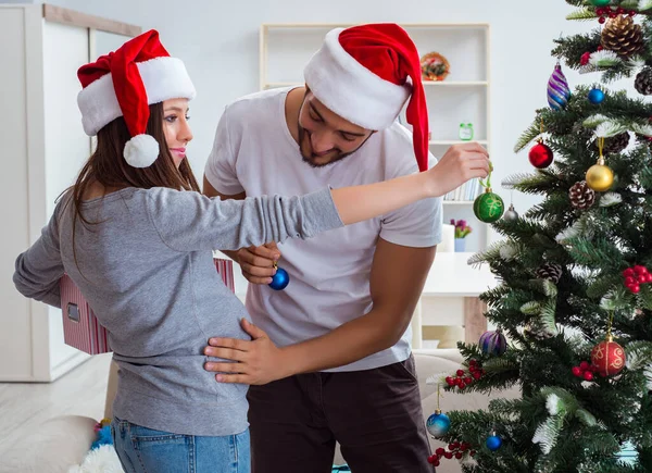 Genç aile Noel 'i kutlayan bir bebek bekliyor.