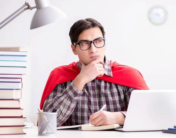 Estudiante súper héroe con una computadora portátil estudiando preparación para los exámenes — Foto de Stock