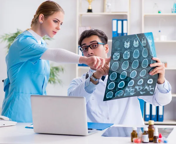 De två läkare som undersöker röntgenbilder av patienten för diagnos — Stockfoto