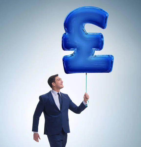 Hombre de negocios caminando con signo de libra británica inflable —  Fotos de Stock