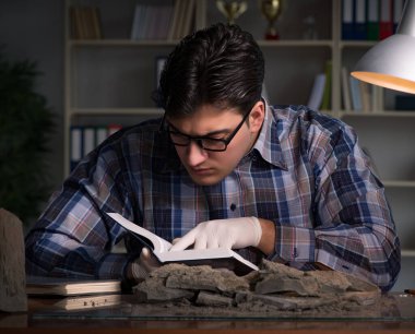 Arkeolog geç saatlere kadar ofiste çalışıyor.