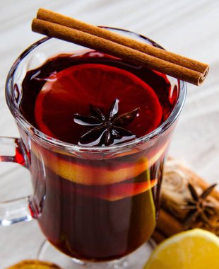 Haşlanmış şarap, yılbaşı masasında servis edilen bardaklarda parlıyor.