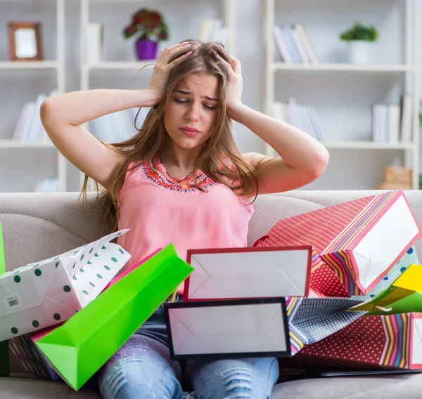 Jonge vrouw met boodschappentassen binnen op de bank — Stockfoto