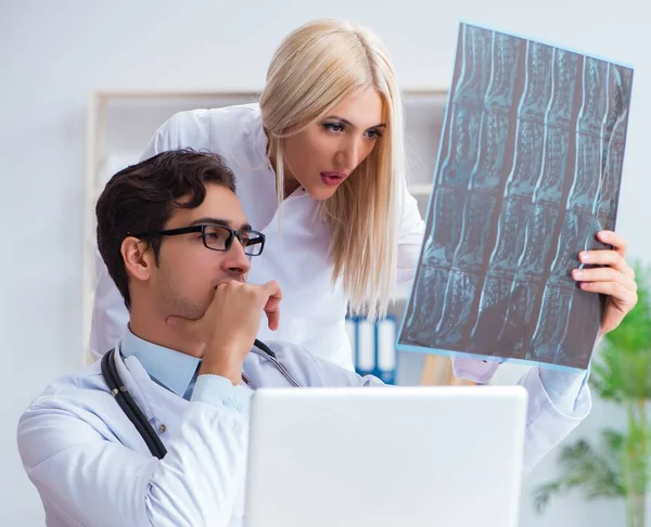 A két orvos, akik röntgenfelvételeket vizsgálnak a betegről diagnózis céljából. — Stock Fotó