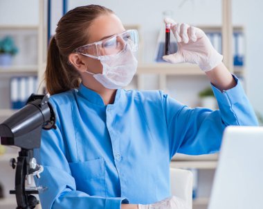 Bir laboratuarda deney yapan kadın bir bilim adamı.