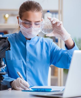 Bir laboratuarda deney yapan kadın bir bilim adamı.