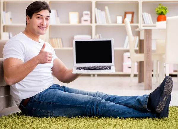 Férfi dolgozik laptop otthon szőnyegpadló — Stock Fotó